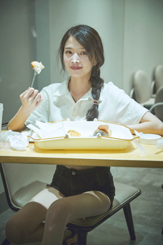 在烘焙店吃面包喝牛奶的可爱亚洲少女图片