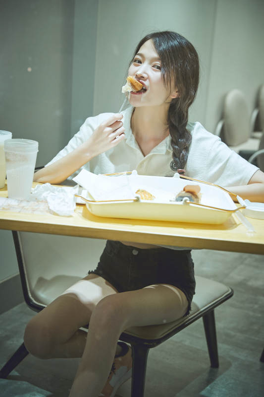 在烘焙店吃面包喝牛奶的可爱亚洲少女图片