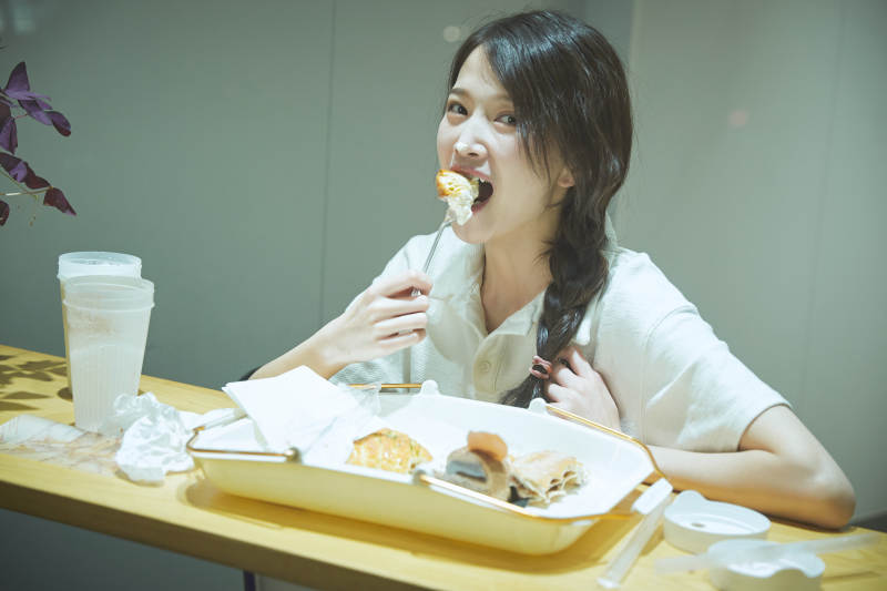 在烘焙店吃面包喝牛奶的可爱亚洲少女图片