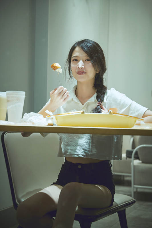 在烘焙店吃面包喝牛奶的可爱亚洲少女图片