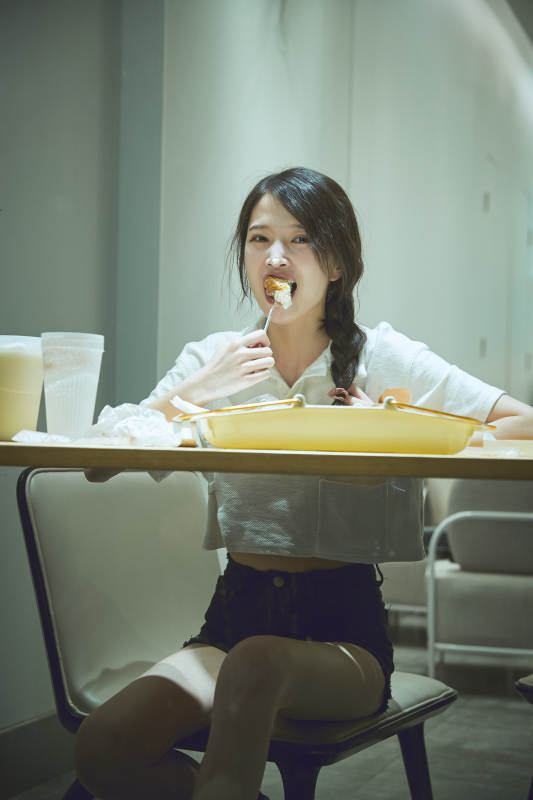 在烘焙店吃面包喝牛奶的可爱亚洲少女图片