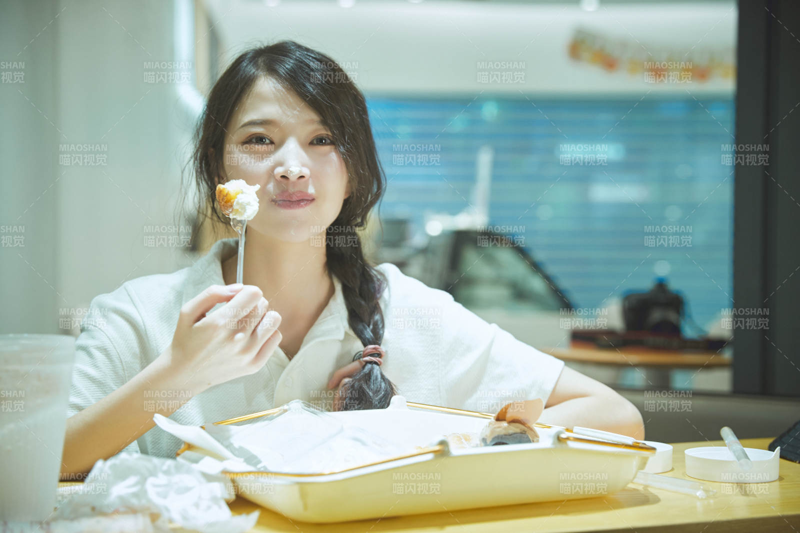 在烘焙店吃面包喝牛奶的可爱亚洲少女图片