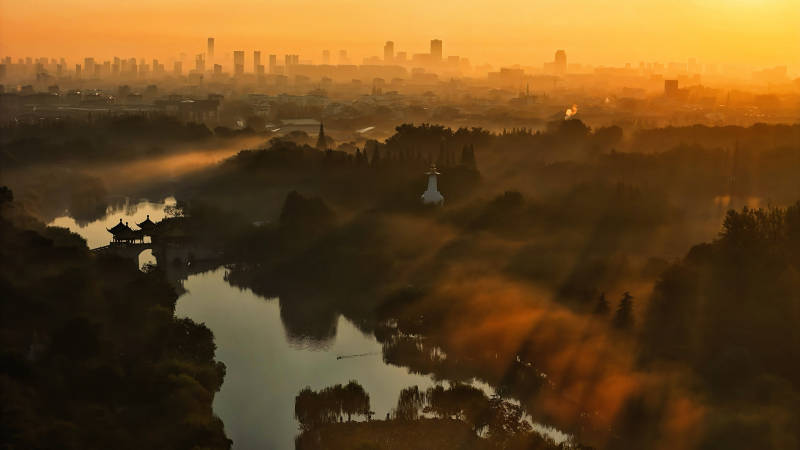 江苏扬州瘦西湖 晨雾中的城市剪影图片