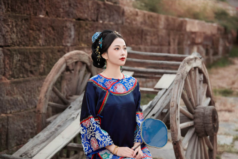 坐在古老手推车上的身穿晚清服饰的美女图片