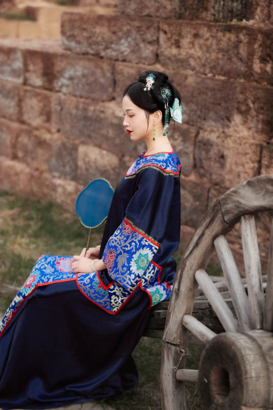 坐在古老手推车上的身穿晚清服饰的美女图片