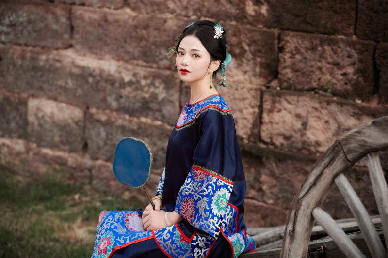 坐在古老手推车上的身穿晚清服饰的美女图片