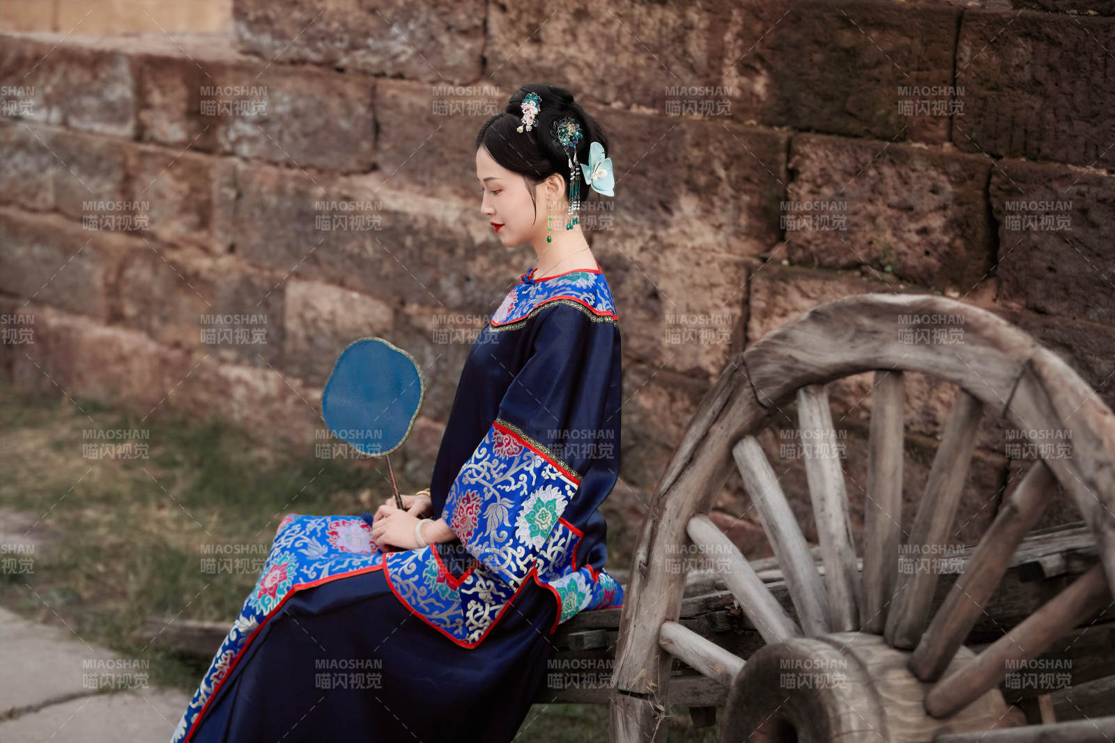 坐在古老手推车上的身穿晚清服饰的美女图片