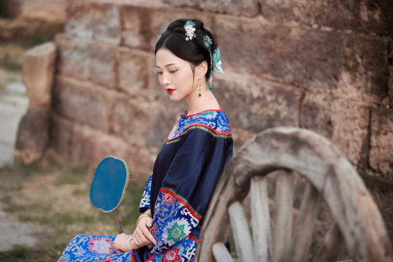 坐在古老手推车上的身穿晚清服饰的美女图片