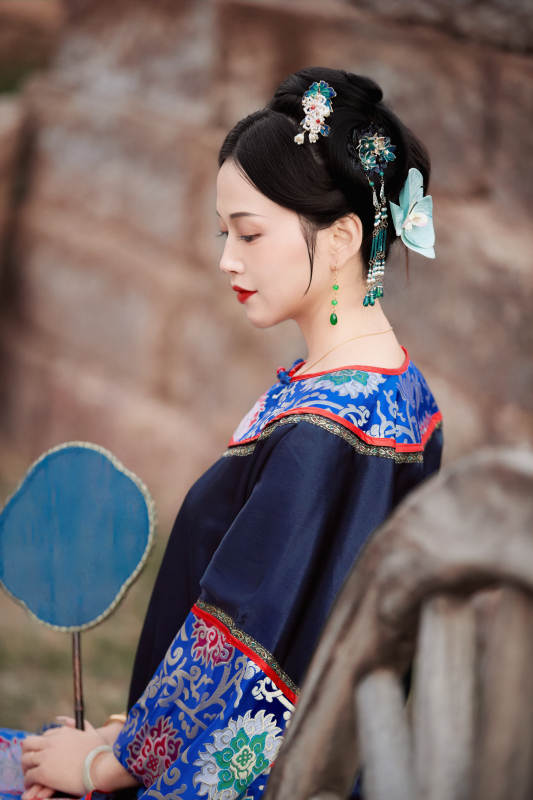 坐在古老手推车上的身穿晚清服饰的美女图片