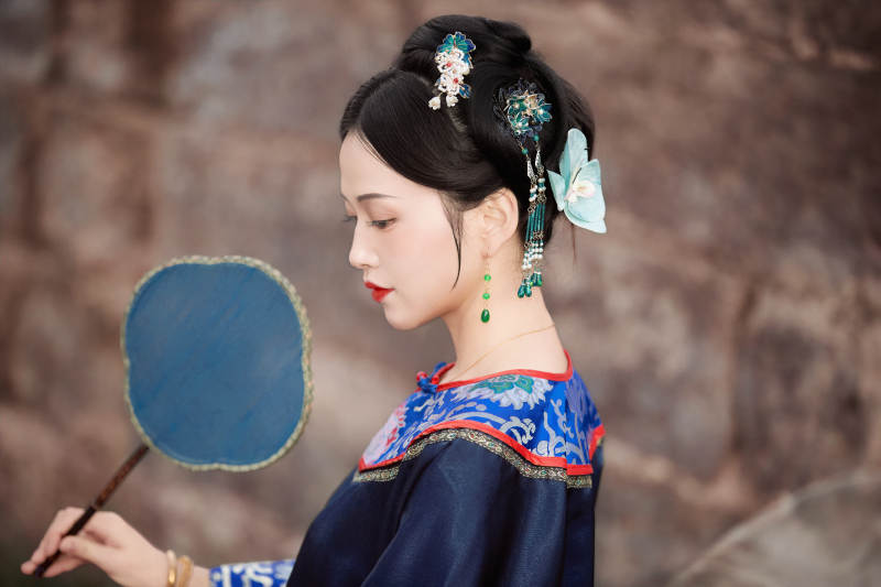 坐在古老手推车上的身穿晚清服饰的美女图片