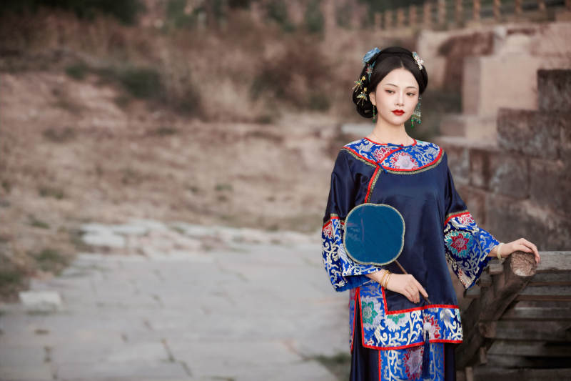 坐在古老手推车上的身穿晚清服饰的美女图片