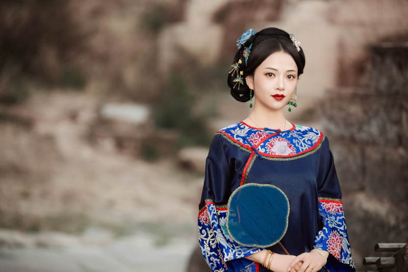 坐在古老手推车上的身穿晚清服饰的美女图片