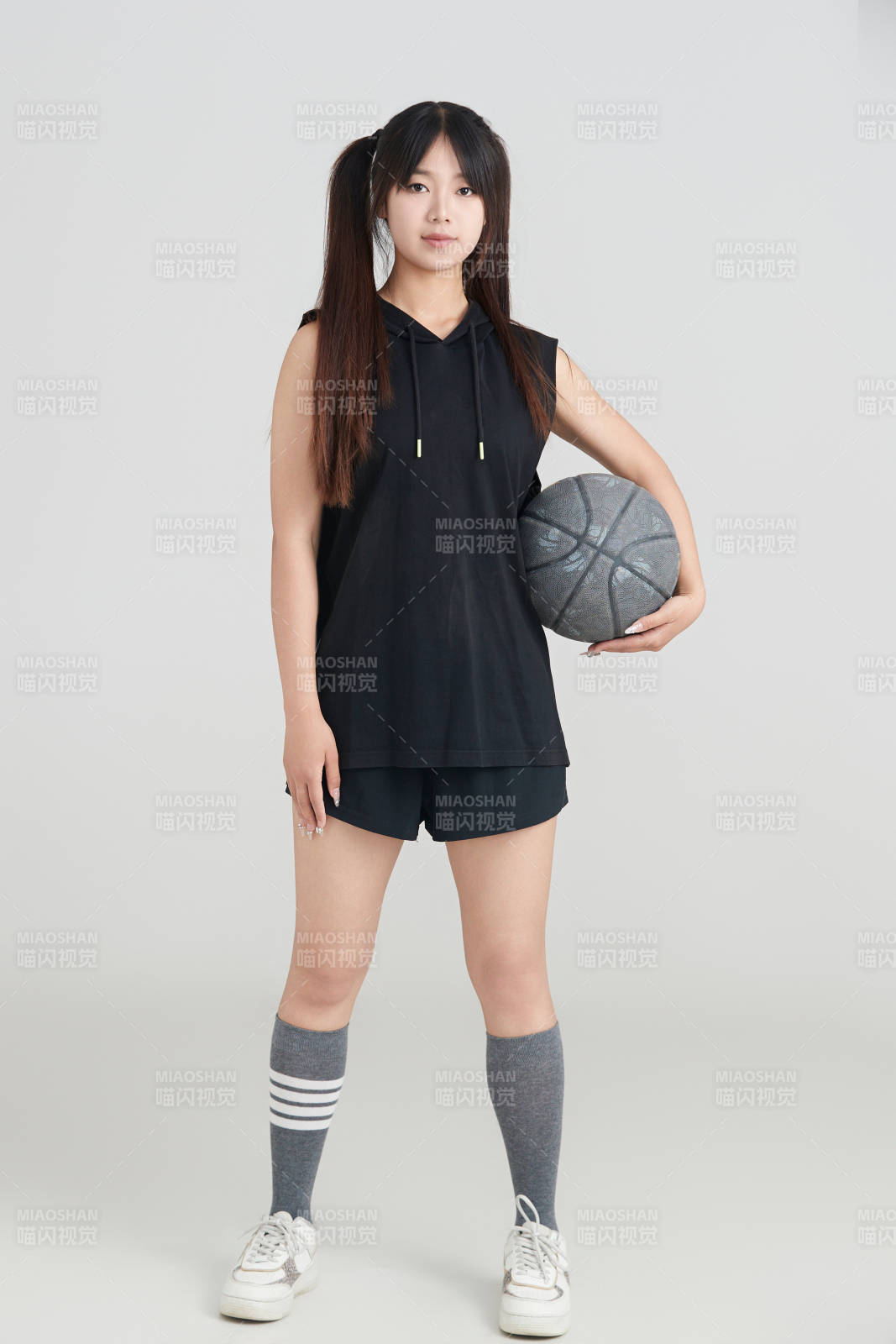 白色背景下的年轻女孩和篮球图片