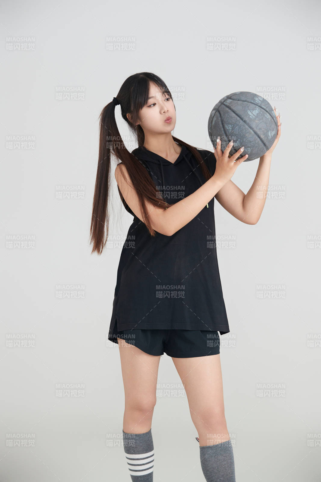 白色背景下的年轻女孩和篮球图片