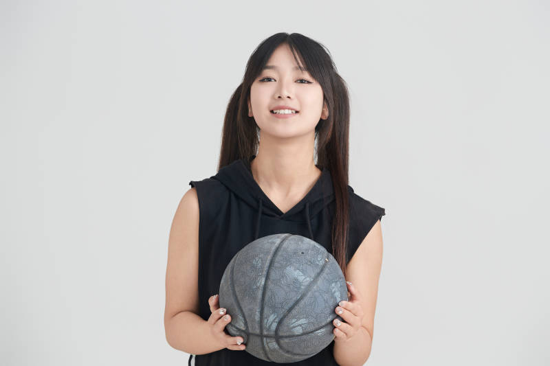 白色背景下的年轻女孩和篮球图片