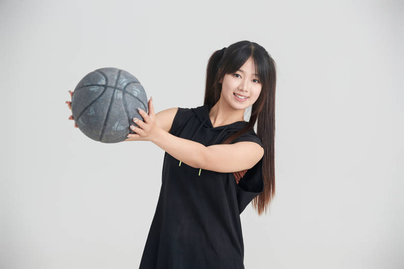 白色背景下的年轻女孩和篮球图片
