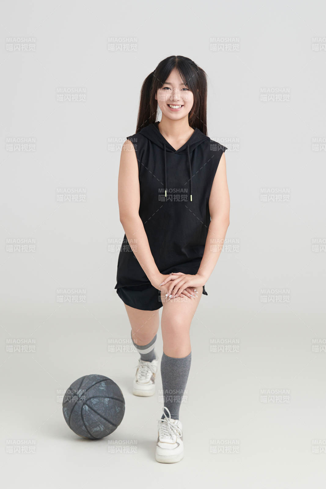 白色背景下的年轻女孩和篮球图片