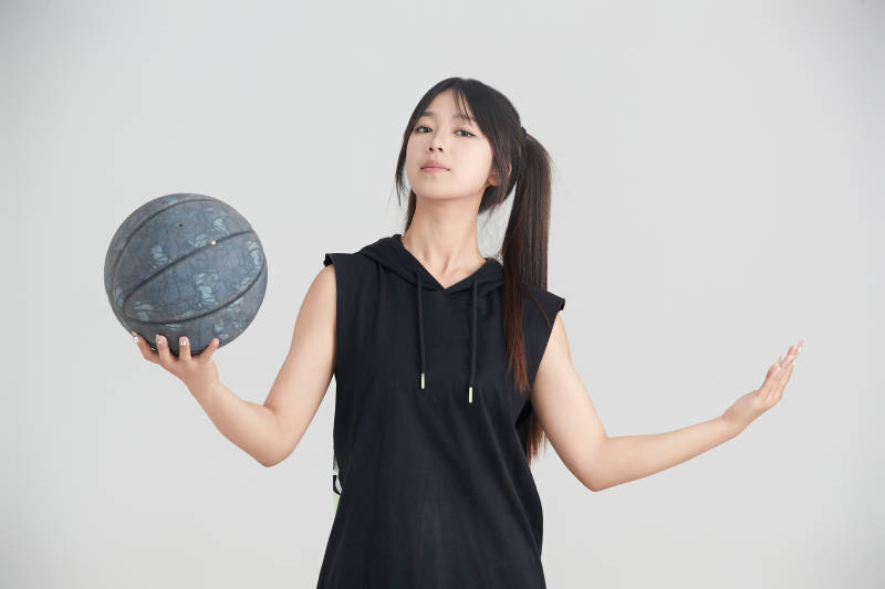白色背景下的年轻女孩和篮球图片