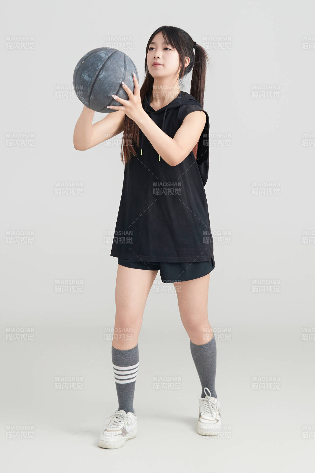 白色背景下的年轻女孩和篮球图片