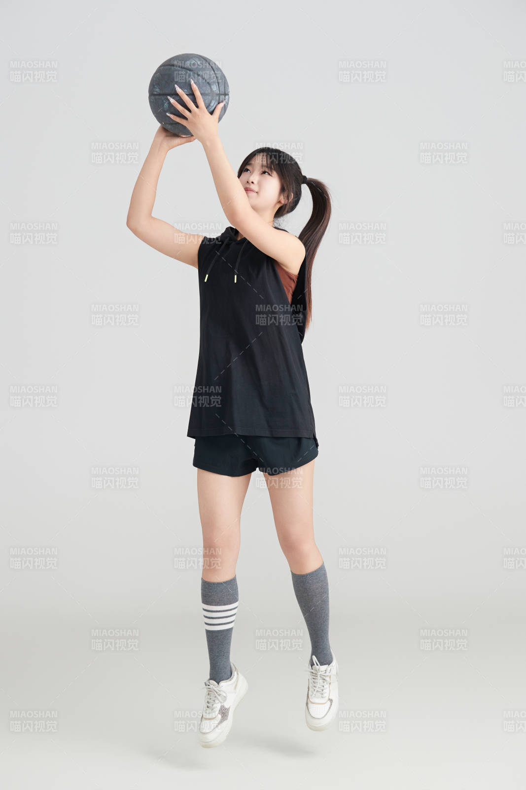 白色背景下的年轻女孩和篮球图片