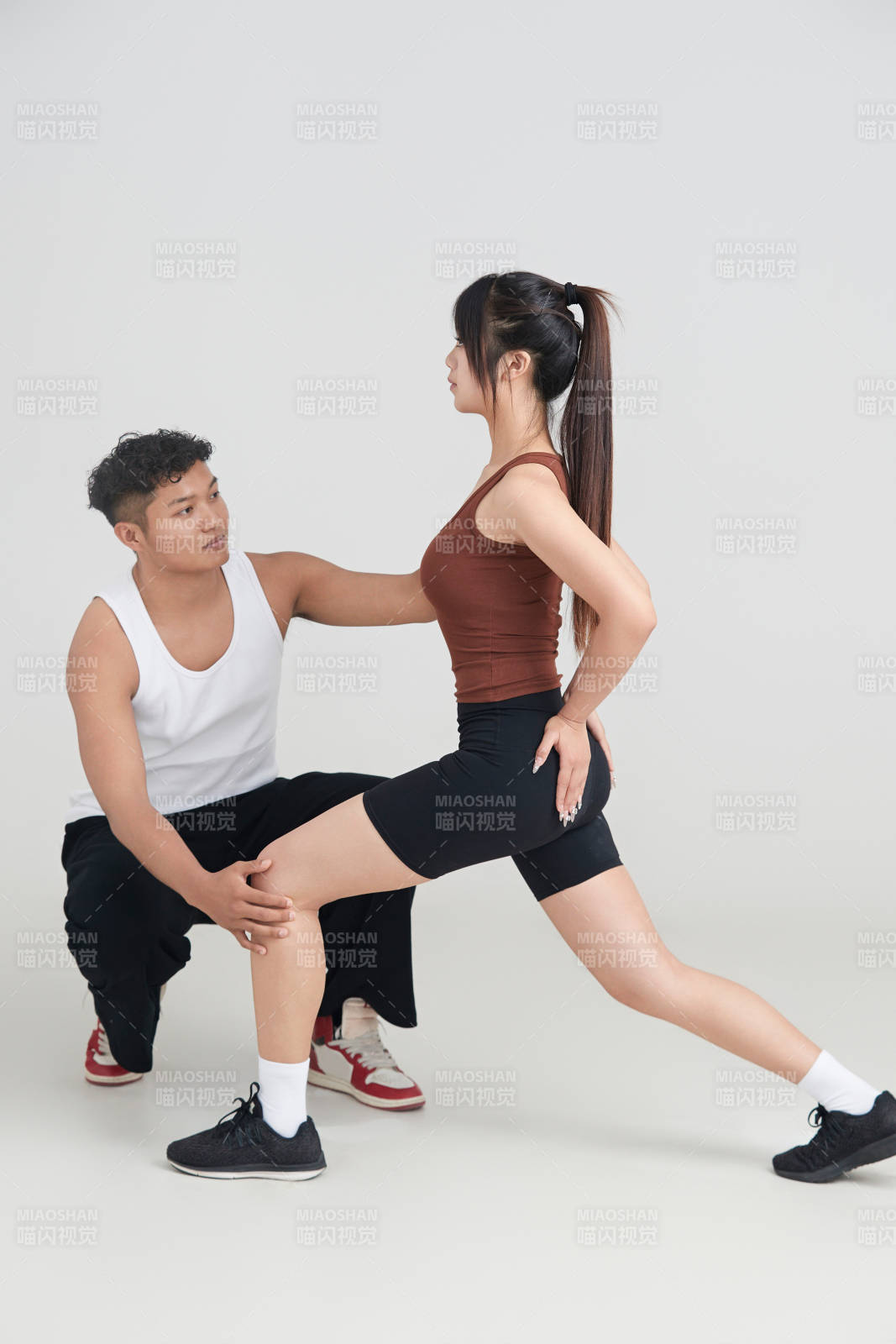 年轻女子在教练的指导下健身图片