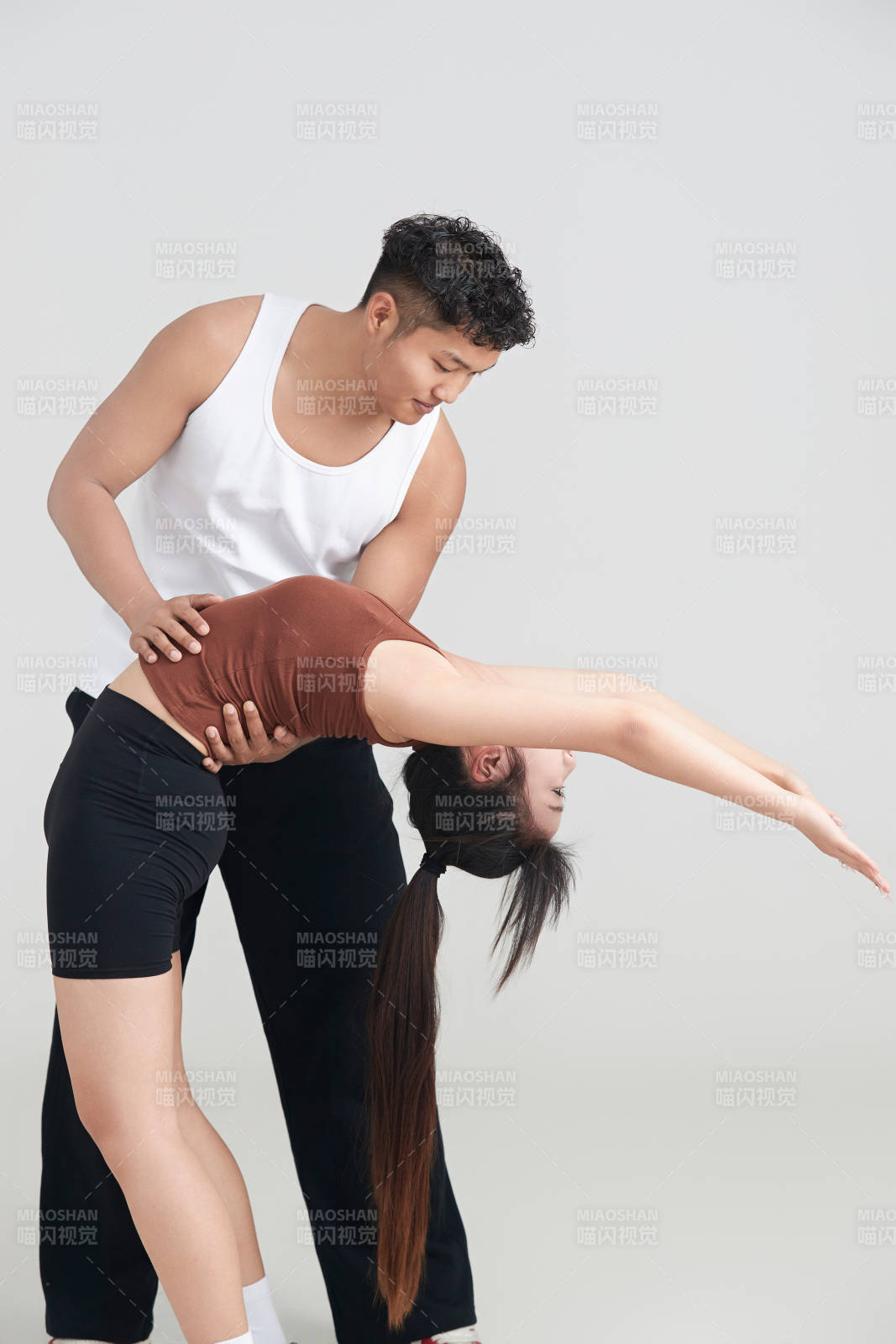 年轻女子在教练的指导下健身图片