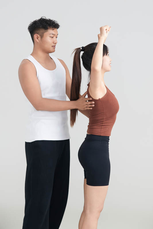 年轻女子在教练的指导下健身图片