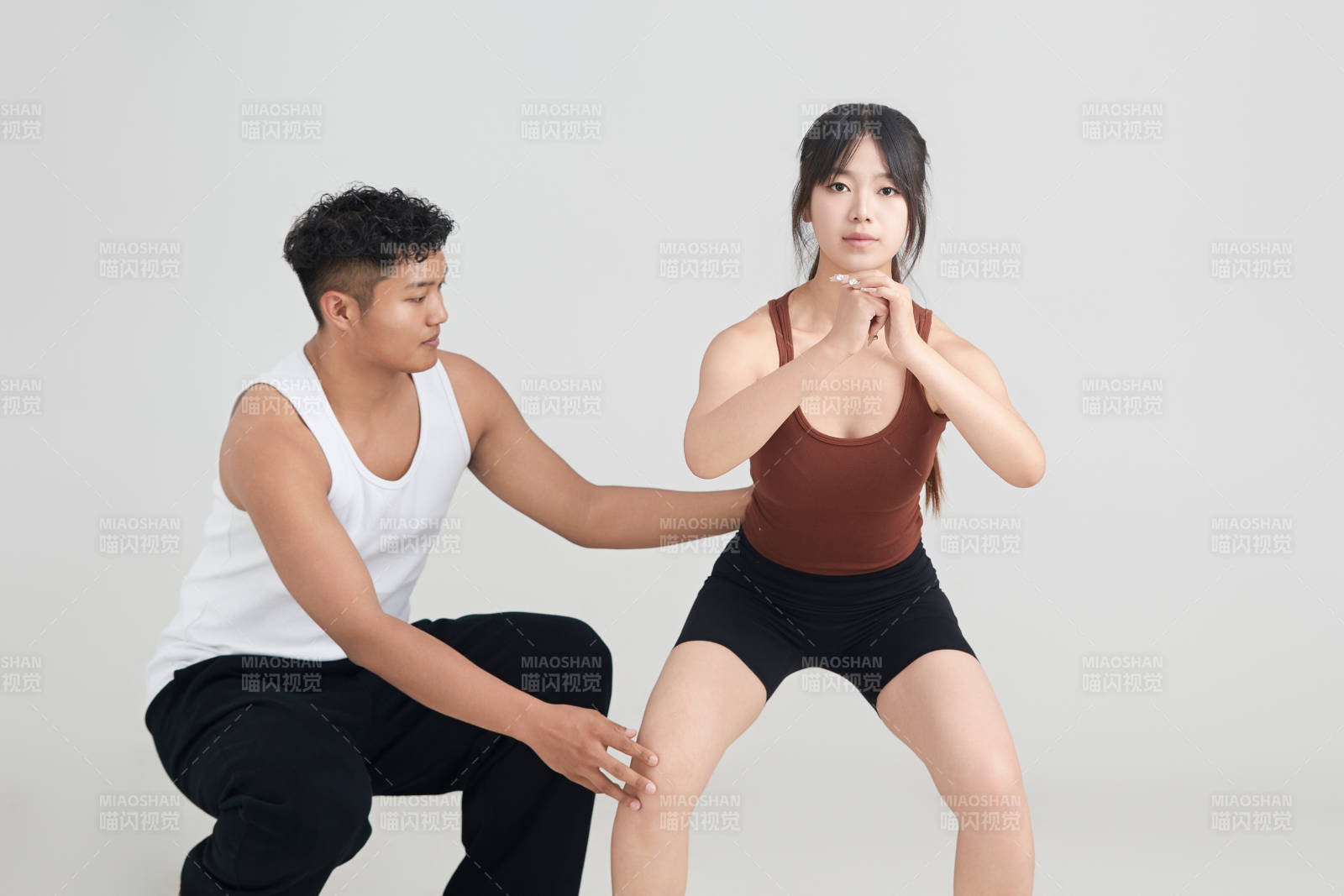 年轻女子在教练的指导下健身图片