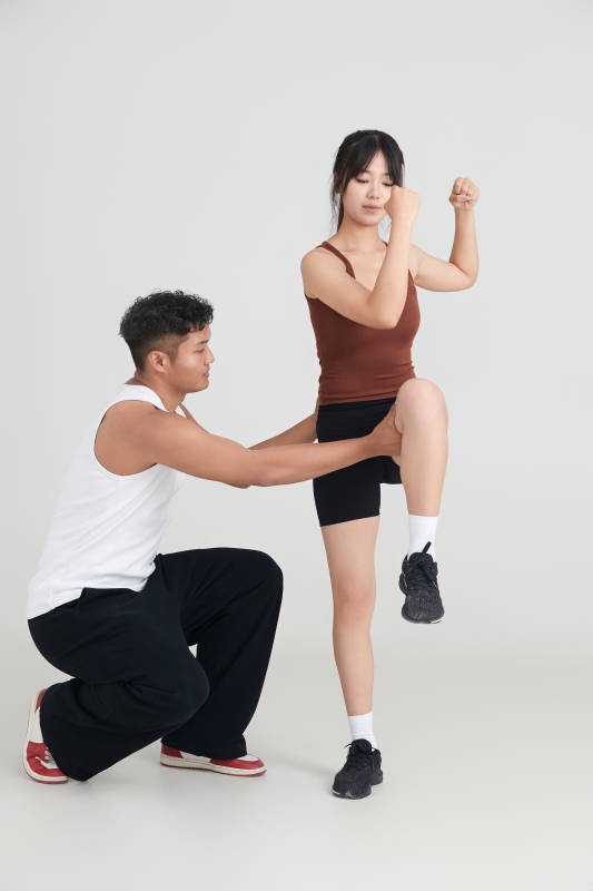 年轻女子在教练的指导下健身图片