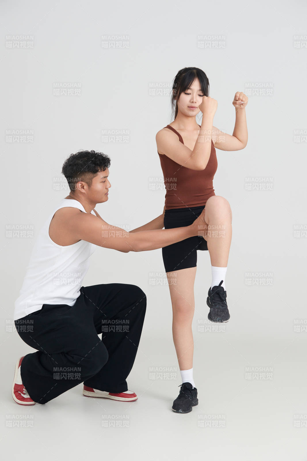 年轻女子在教练的指导下健身图片