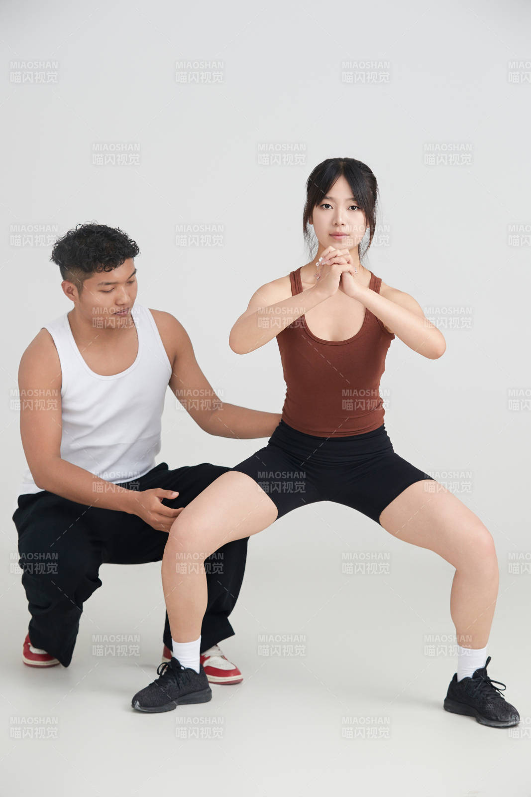 年轻女子在教练的指导下健身图片