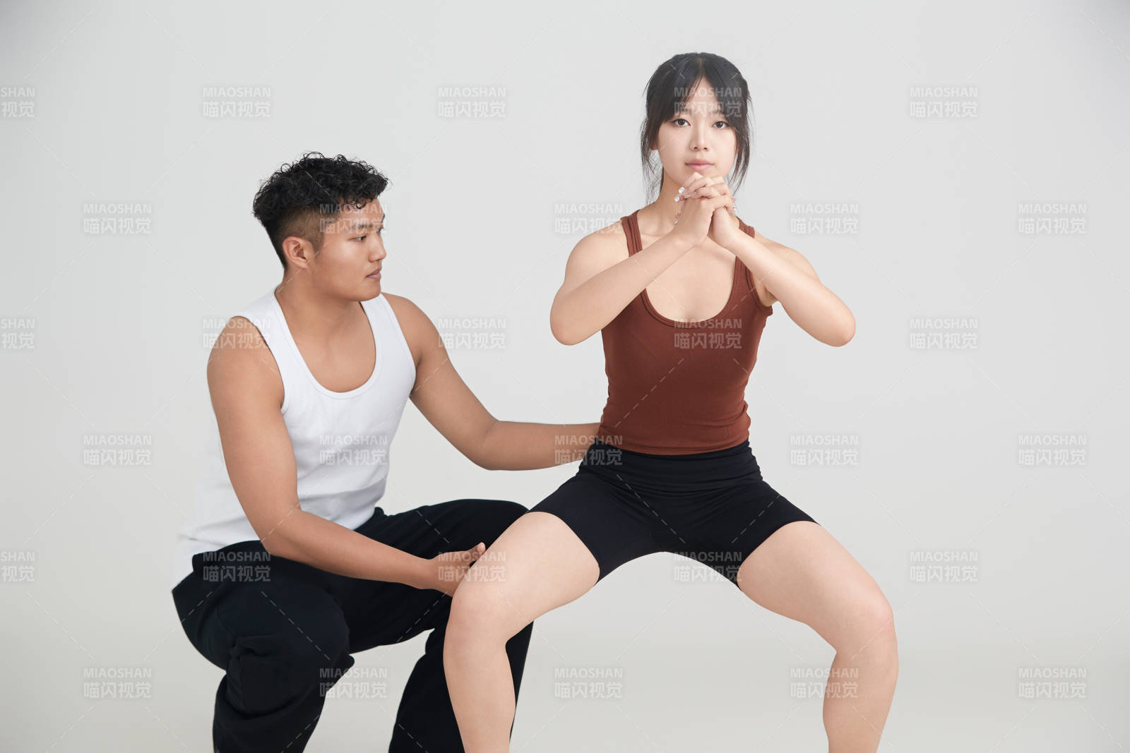 年轻女子在教练的指导下健身图片