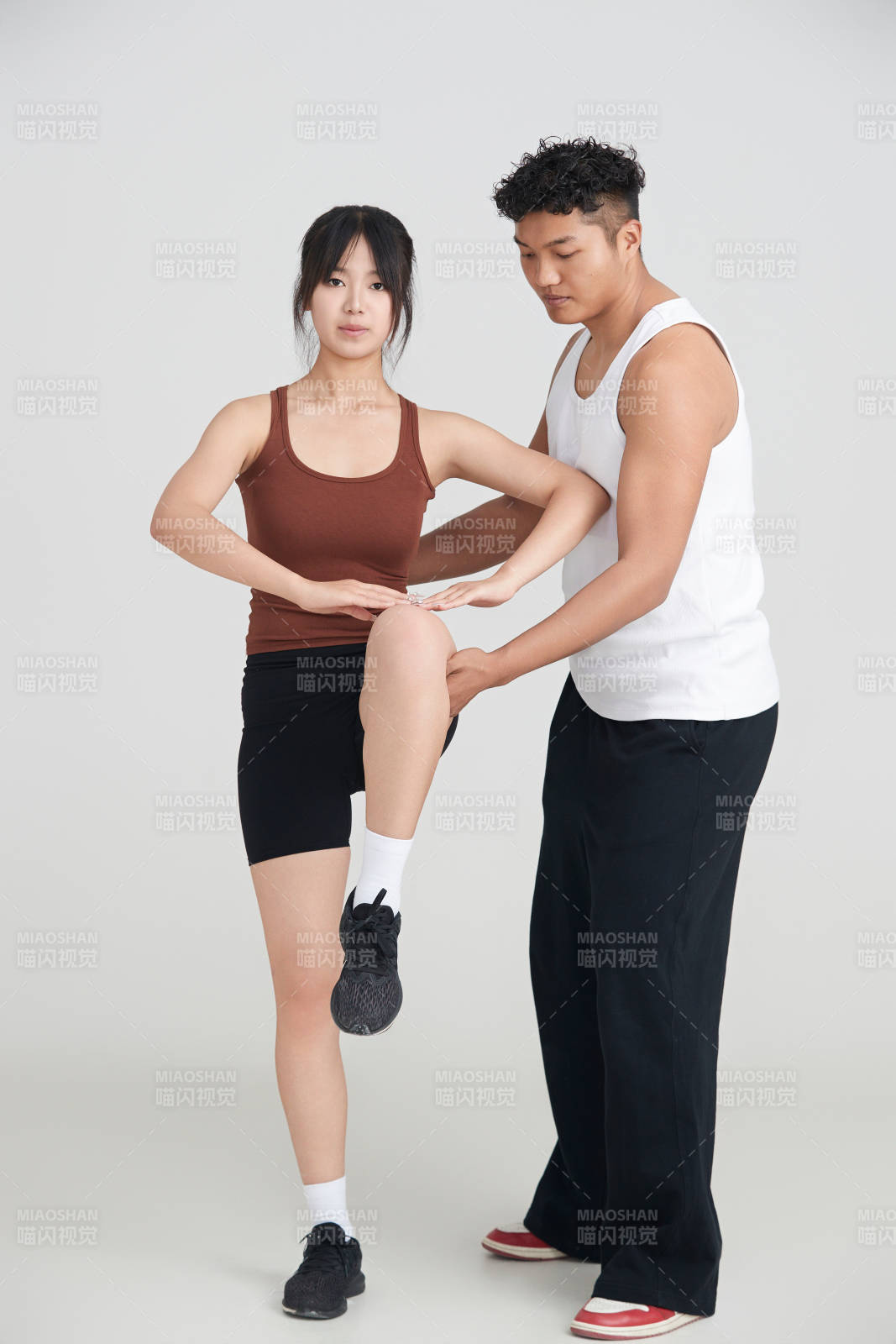 年轻女子在教练的指导下健身图片