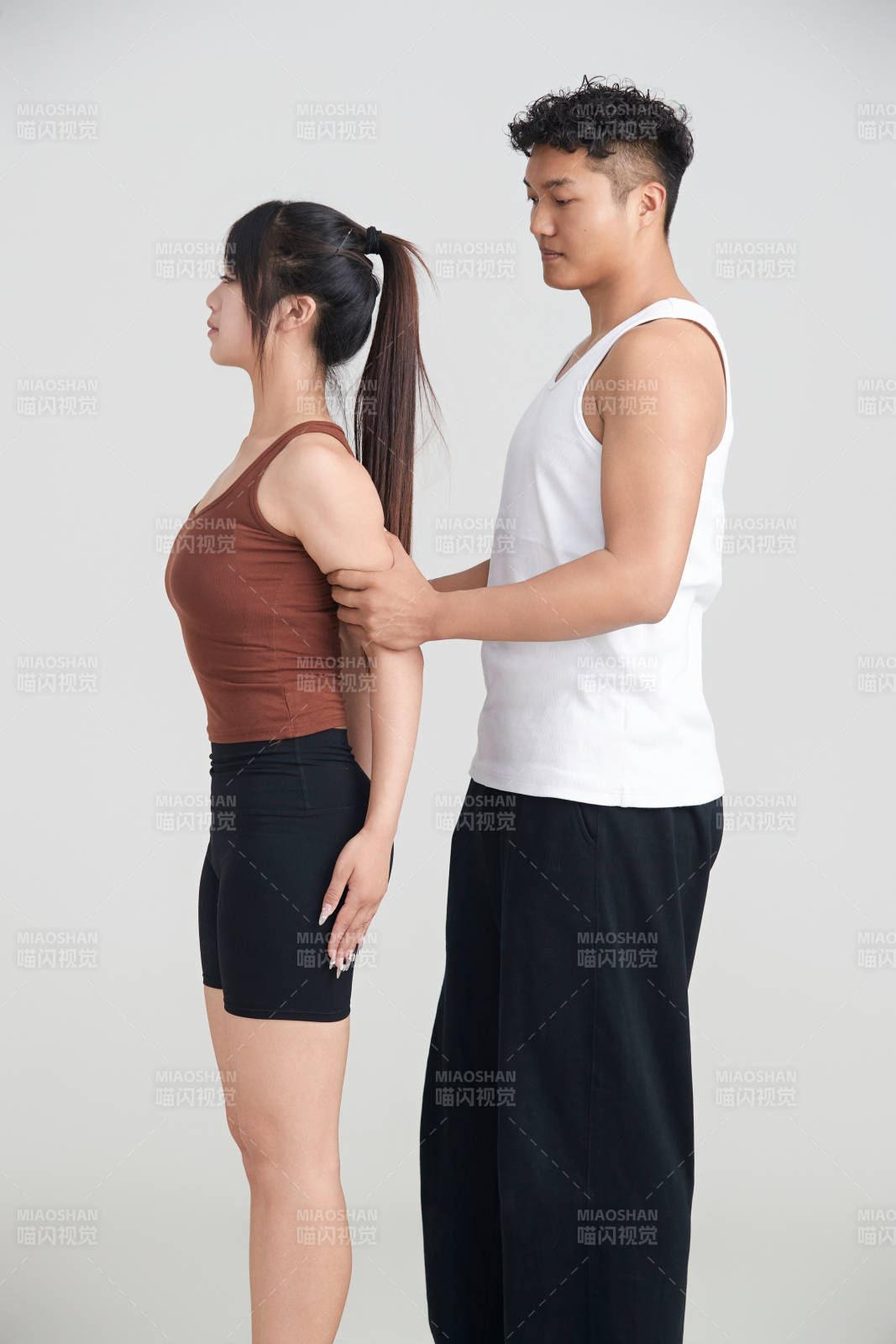 年轻女子在教练的指导下健身图片