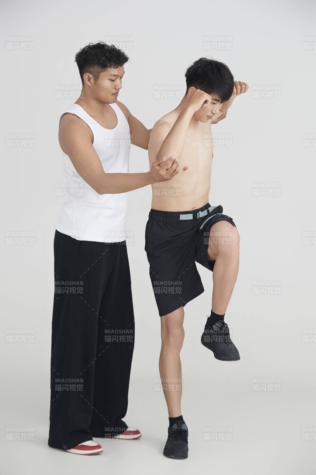 年轻男子在教练的指导下健身图片