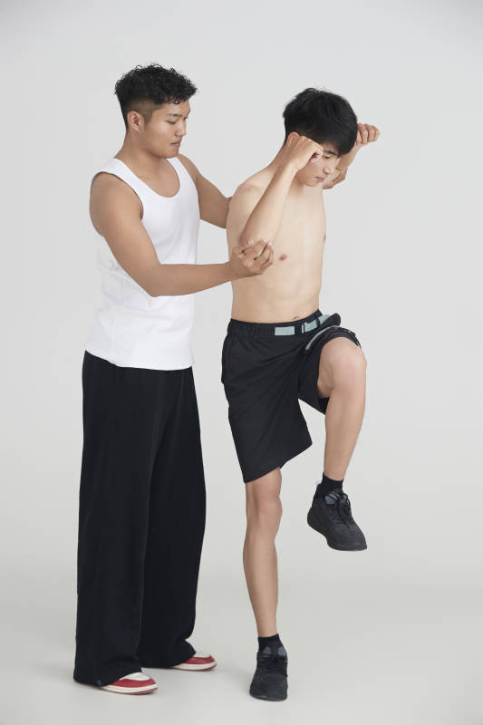 年轻男子在教练的指导下健身图片