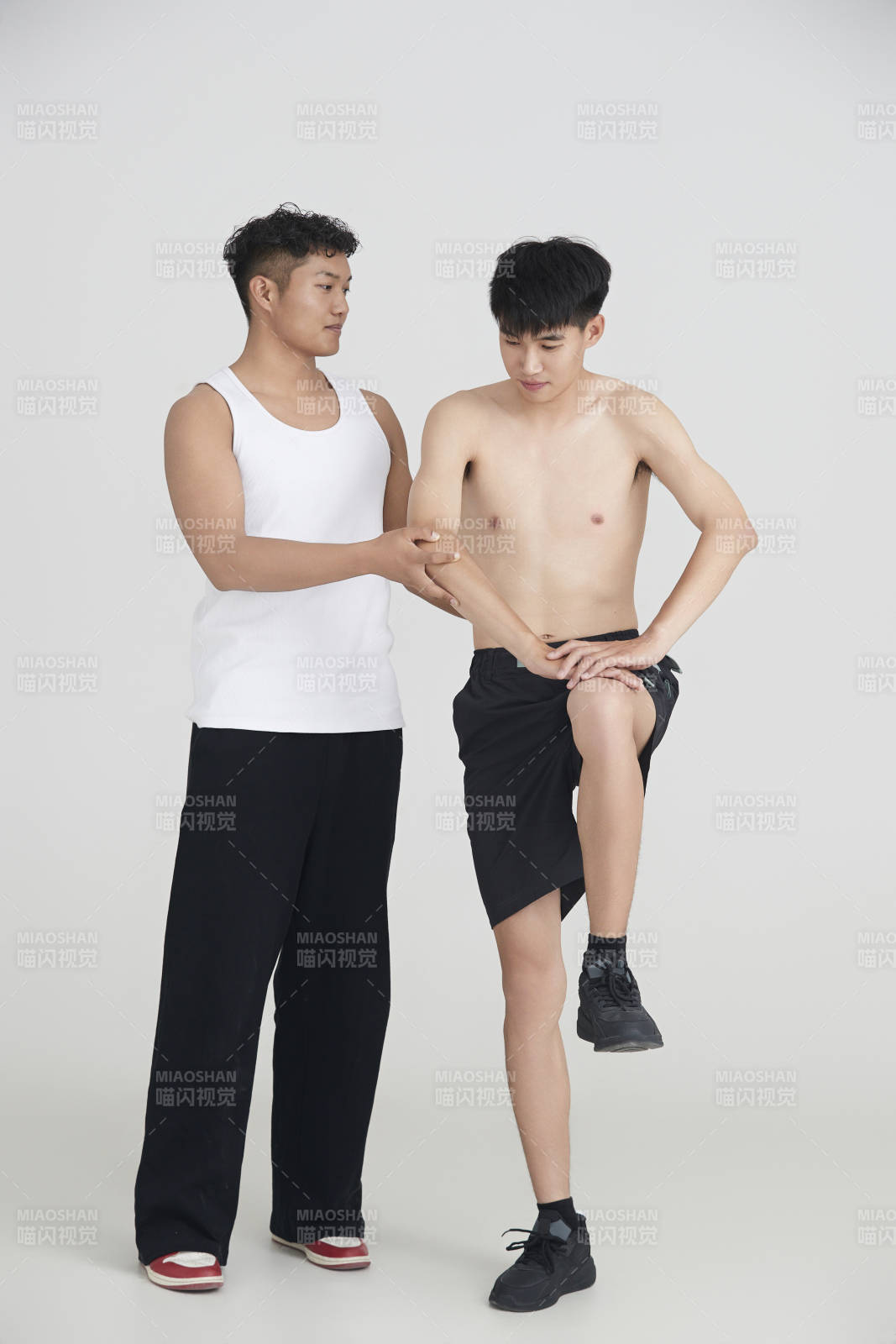 年轻男子在教练的指导下健身图片