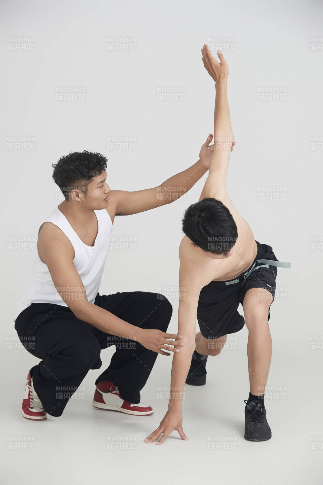 年轻男子在教练的指导下健身图片