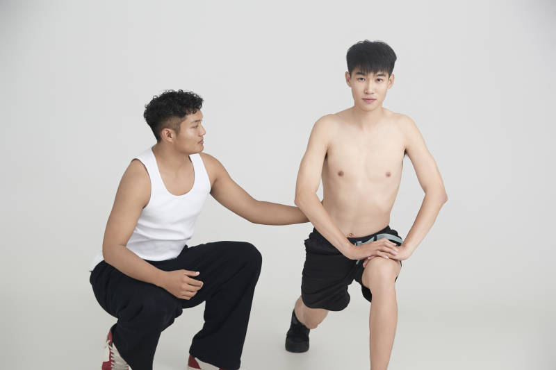 年轻男子在教练的指导下健身图片