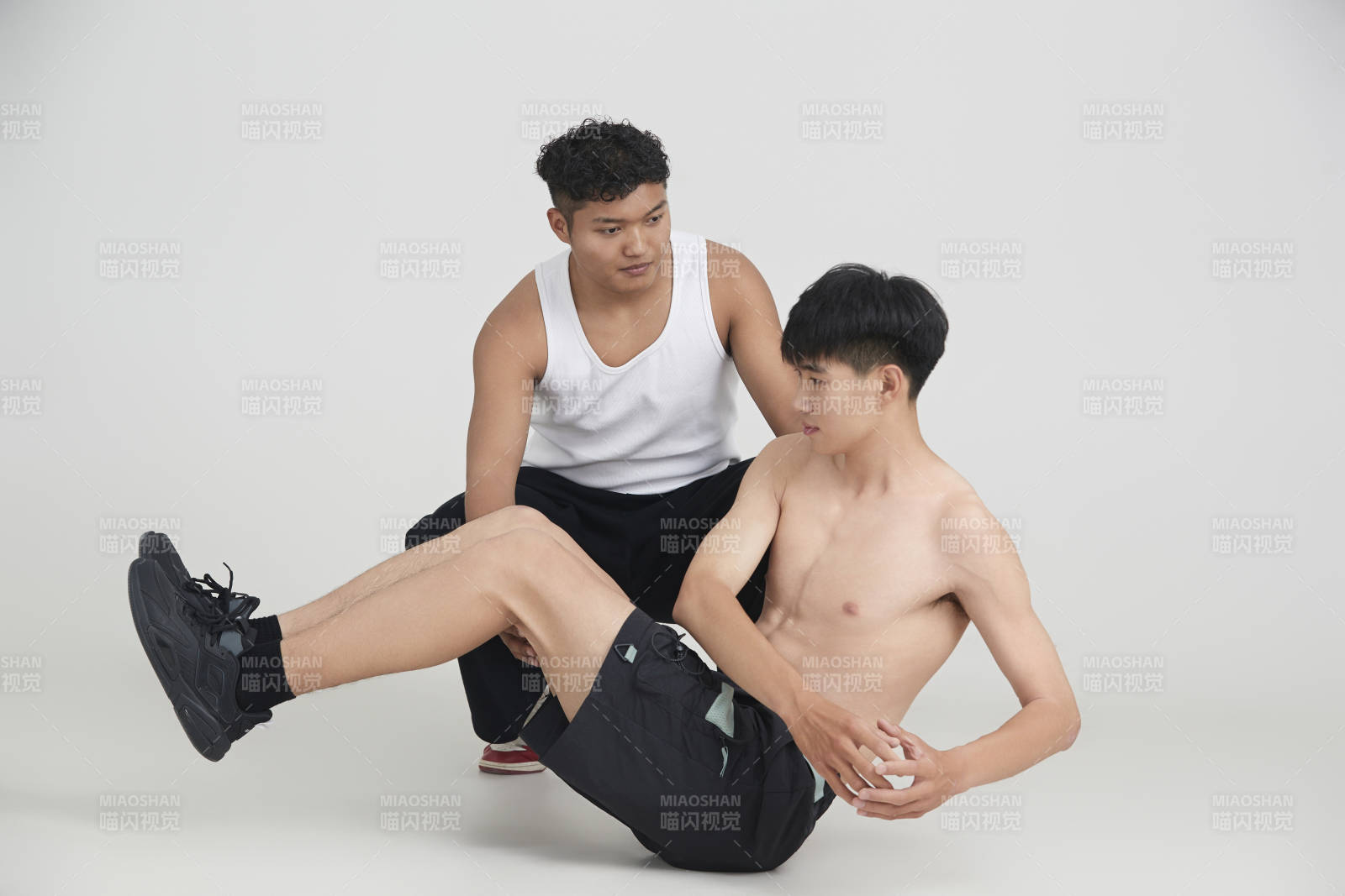 年轻男子在教练的指导下健身图片