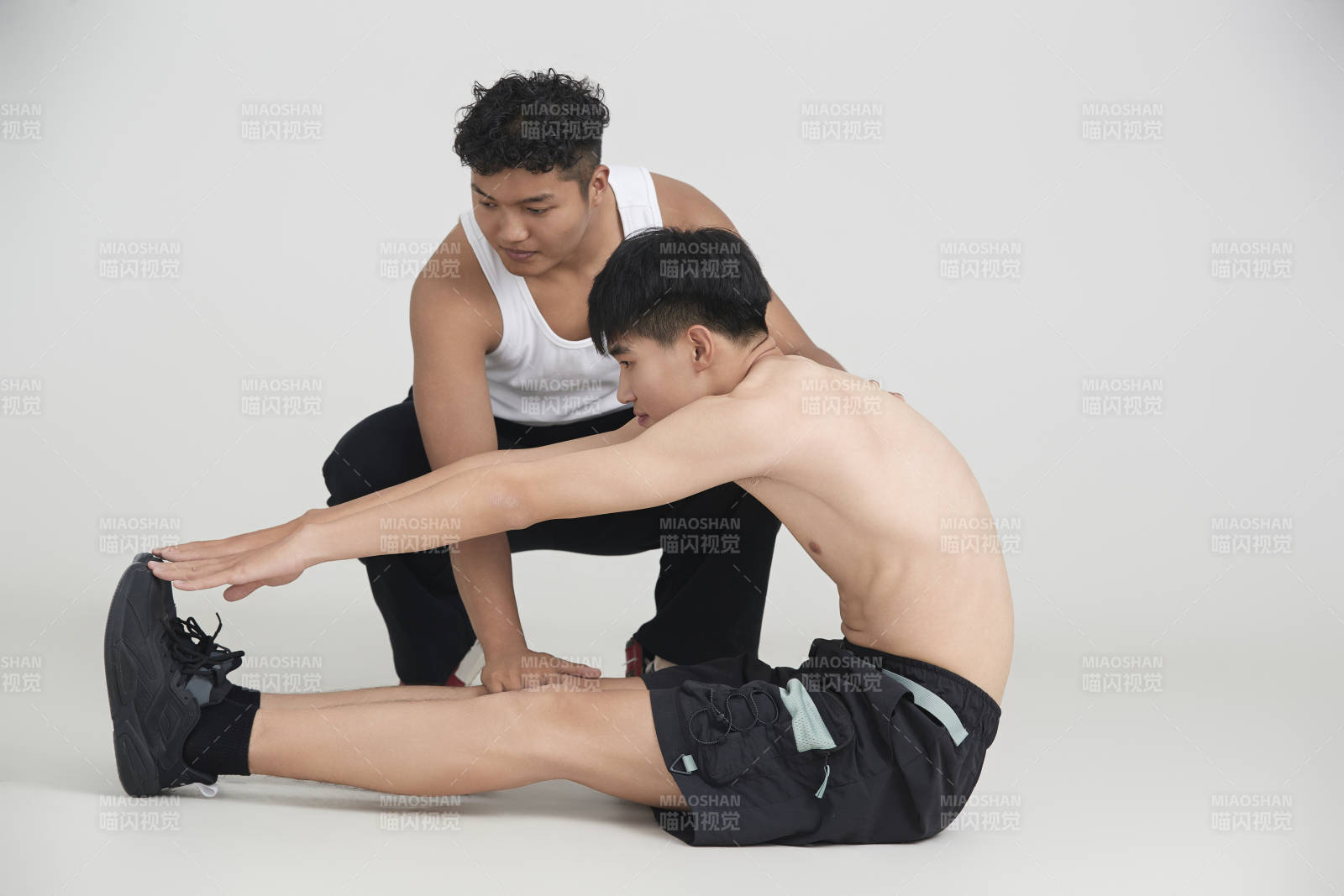 年轻男子在教练的指导下健身图片