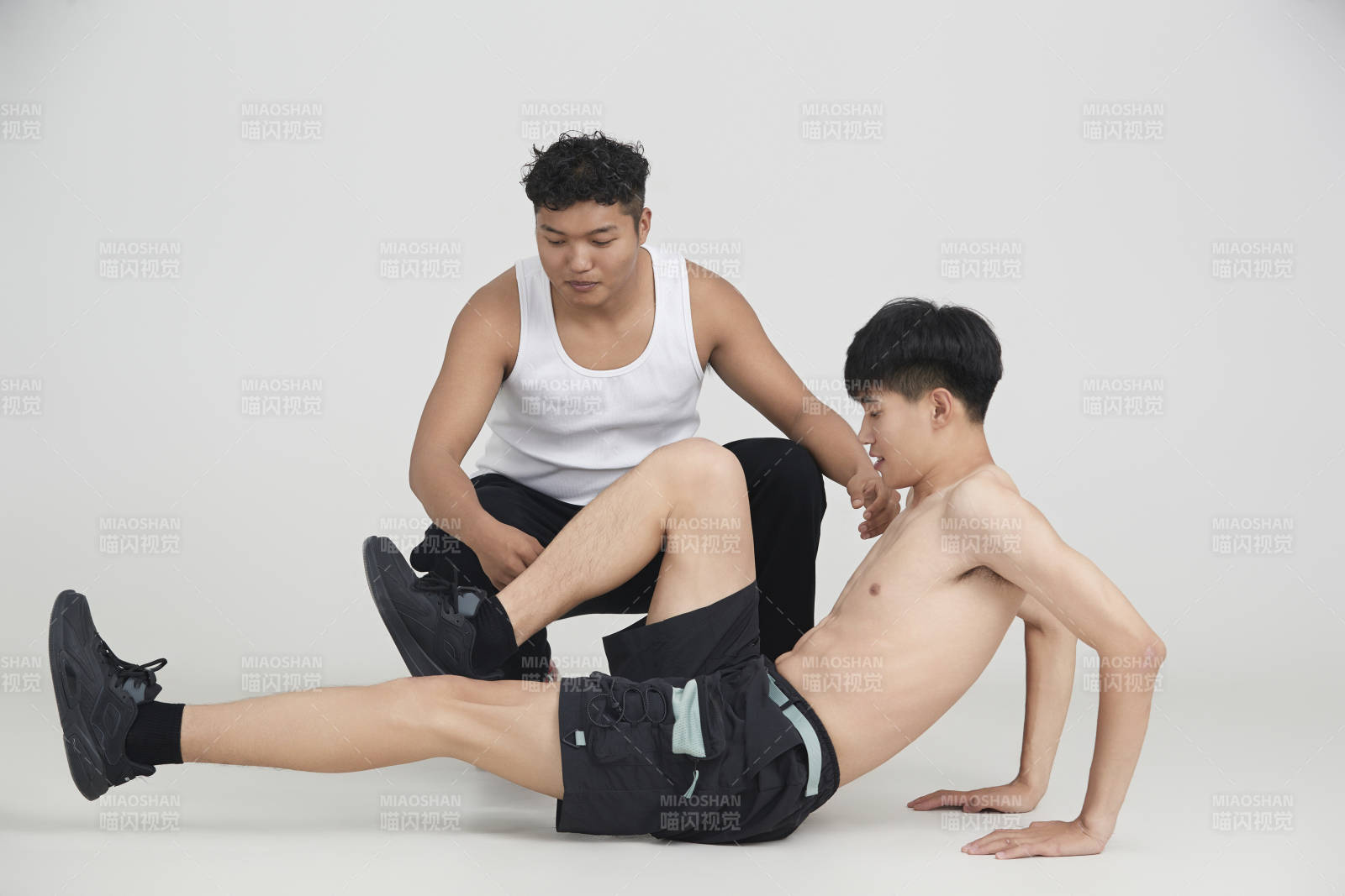 年轻男子在教练的指导下健身图片