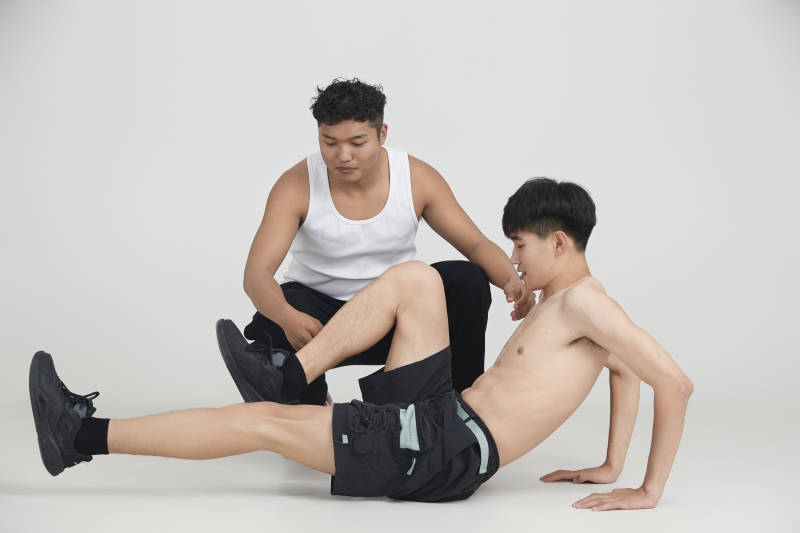 年轻男子在教练的指导下健身图片