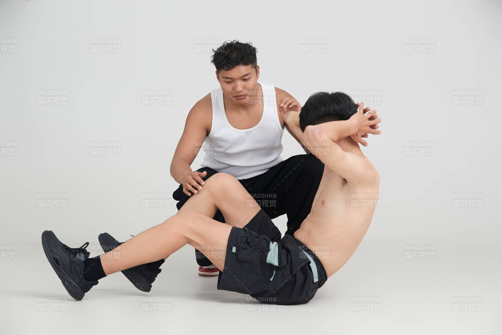 年轻男子在教练的指导下健身图片