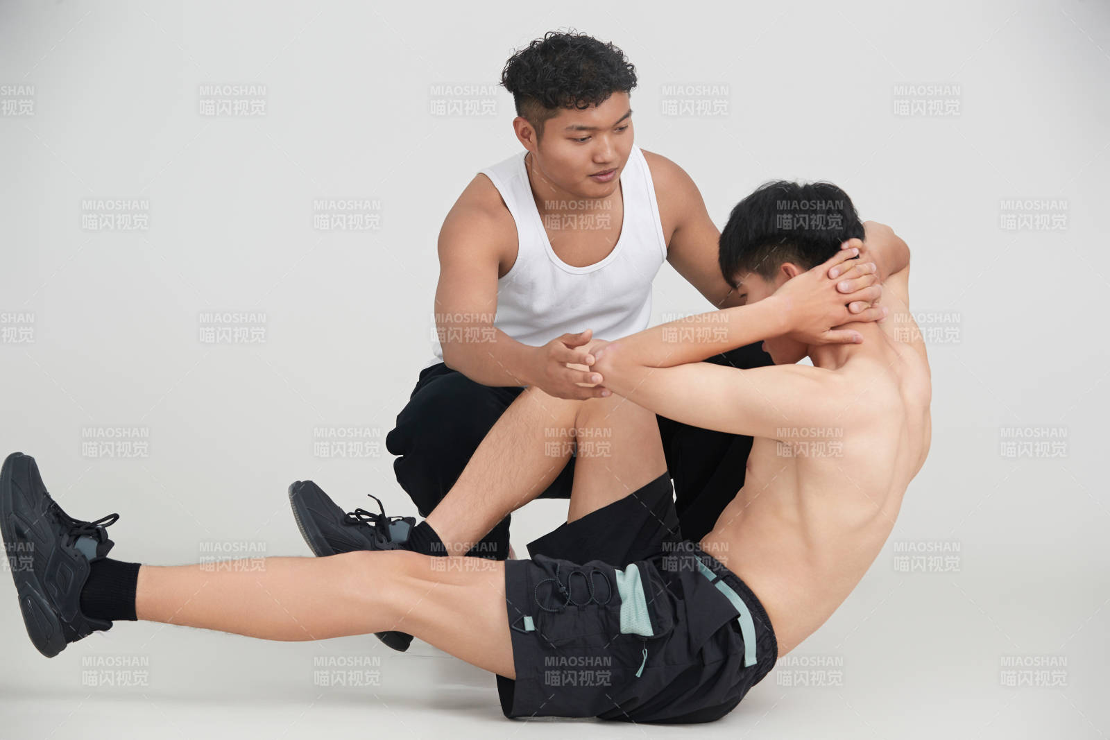 年轻男子在教练的指导下健身图片