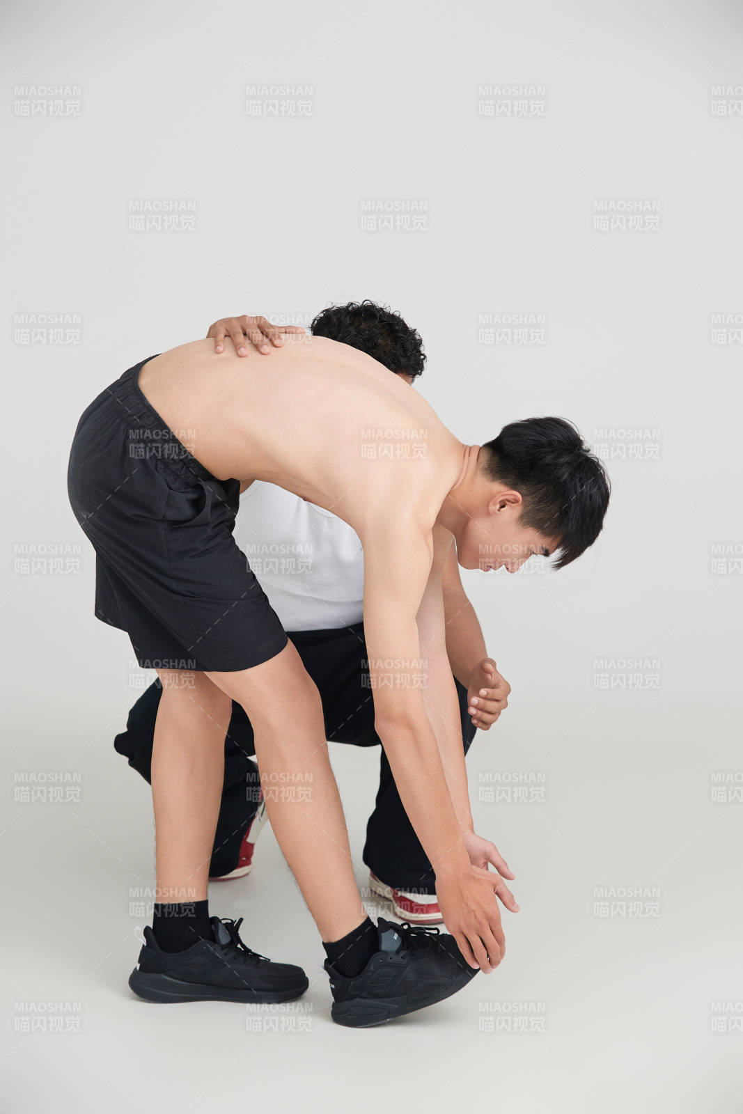 年轻男子在教练的指导下健身图片