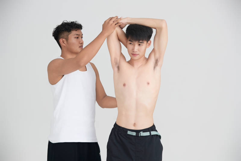 年轻男子在教练的指导下健身图片