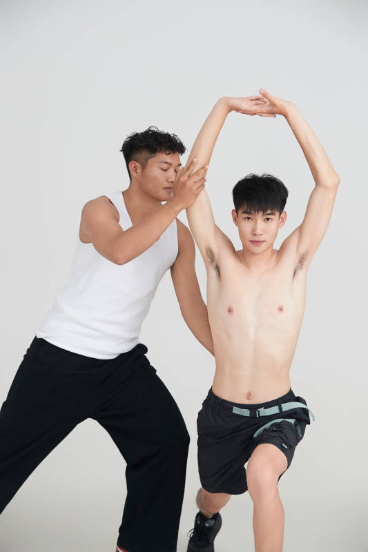 年轻男子在教练的指导下健身图片