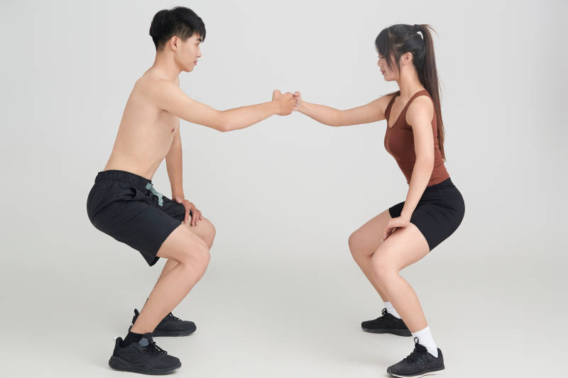 年轻男子在美女教练的指导下健身图片