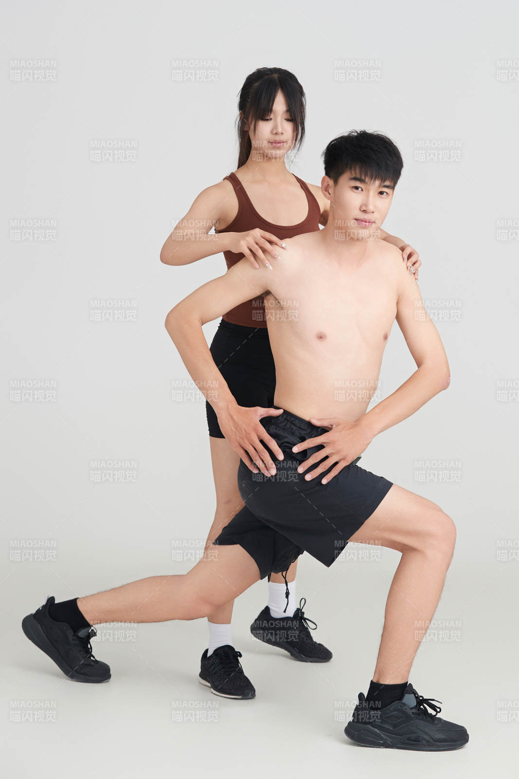 年轻男子在美女教练的指导下健身图片